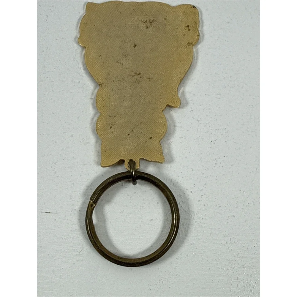 Black cat enamel keychain with gold-toned metal accents and a red bow